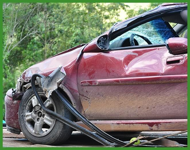 A dirty, damaged car in a yard.