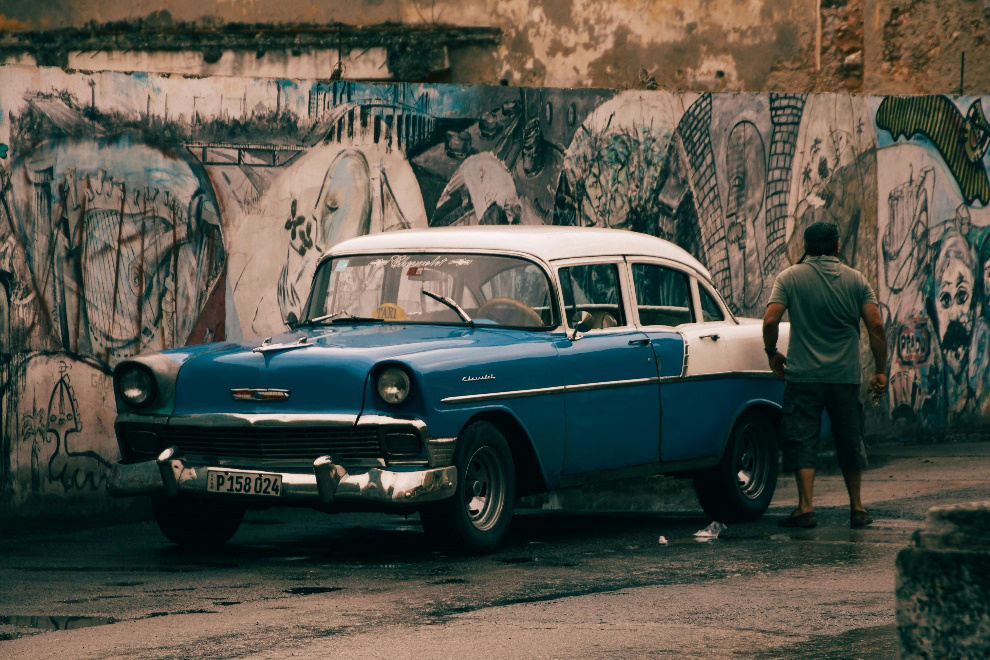 Car parked next to a graffiti wall