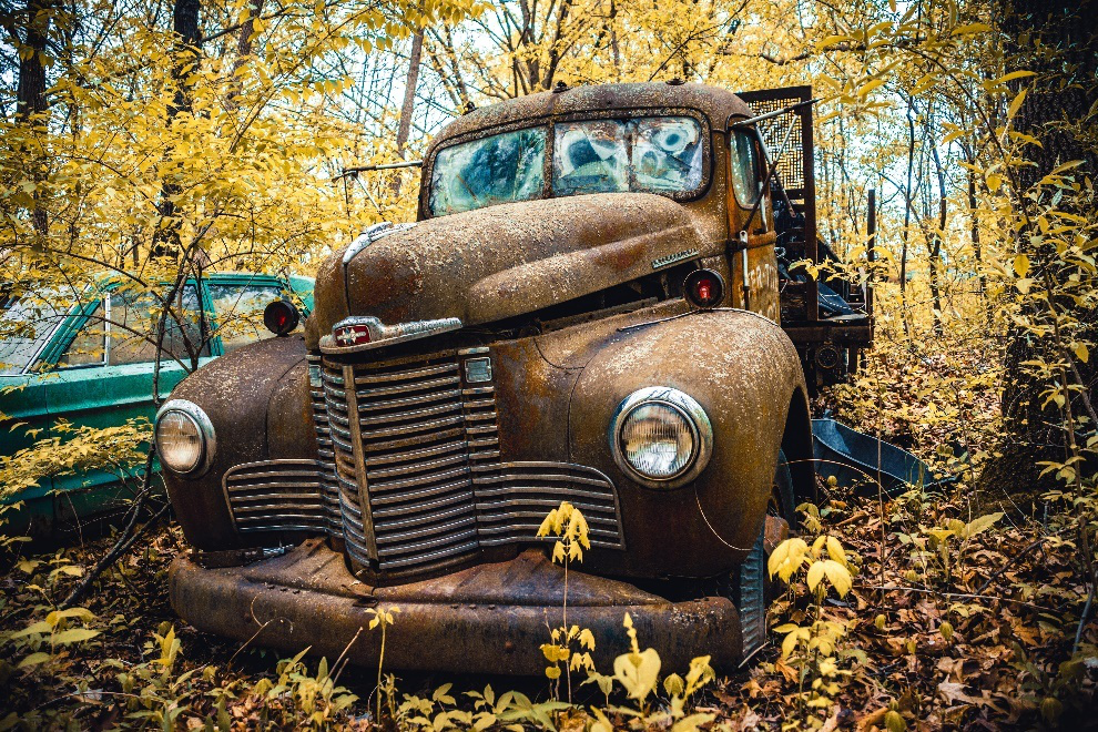 Rusted old car parked in an autumnal setting