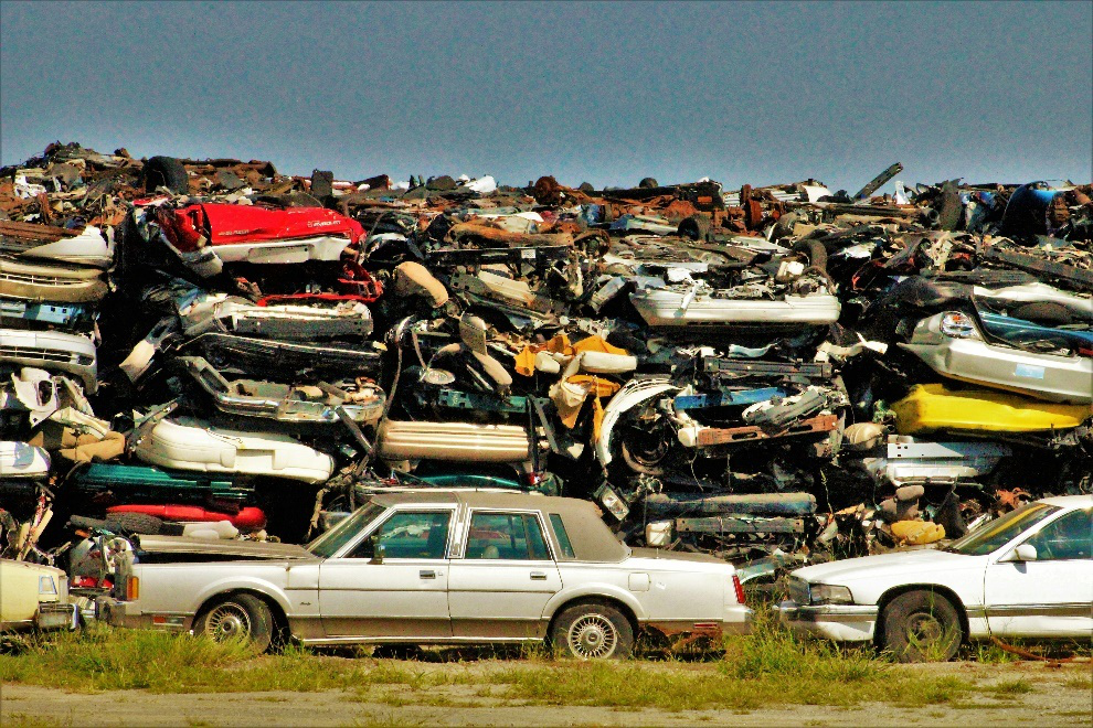 Junk cars stacked atop each other in a salvage yard 