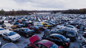 Aerial view of a large car junkyard with rows of old vehicles.